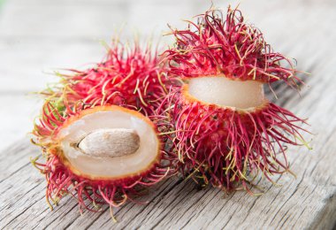 Ahşap doku arka plan üzerinde taze rambutan.