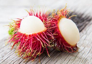 Ahşap doku üzerinde taze kırmızı rambutan.
