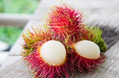 Ahşap doku üzerinde taze kırmızı rambutan.