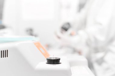 Bulanık bilim adamı beyaz sesi mikroskobu ile çalışma.