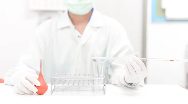 Científico borroso trabajando con microscopio en tono blanco . — Foto de Stock