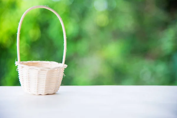 Basket on wooden desk in garden and free space — Stock Photo, Image
