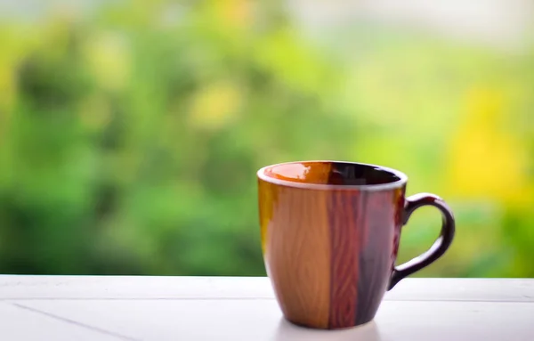 Кофейная чашка на зеленом фоне размытия . — стоковое фото