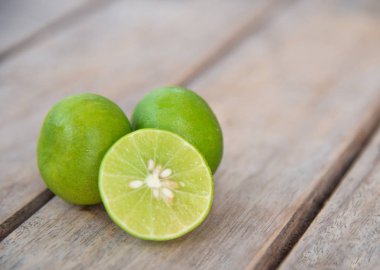 Ahşap masa üzerinde taze yeşil limon.
