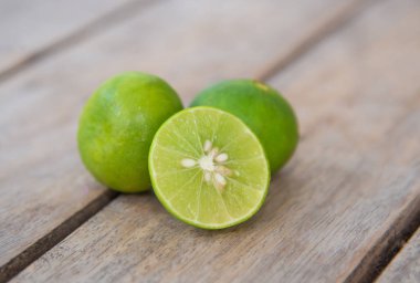 Ahşap masa üzerinde taze yeşil limon.