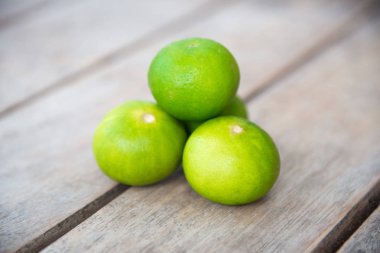 Ahşap masa üzerinde taze yeşil limon.