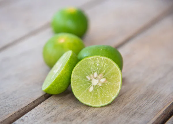 Čerstvý zelený citron na dřevo stůl. — Stock fotografie