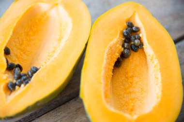 Ahşap masa üzerinde sarı papaya meyve.