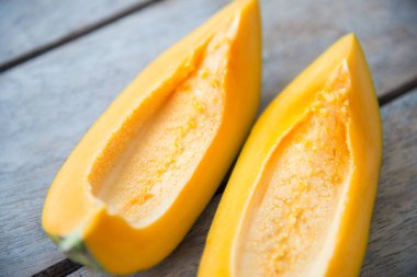 Ahşap masa üzerinde sarı papaya meyve.