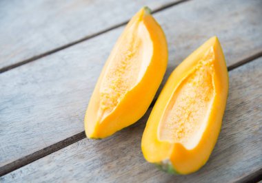 Ahşap masa üzerinde sarı papaya meyve.