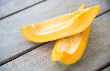 Ahşap masa üzerinde sarı papaya meyve.