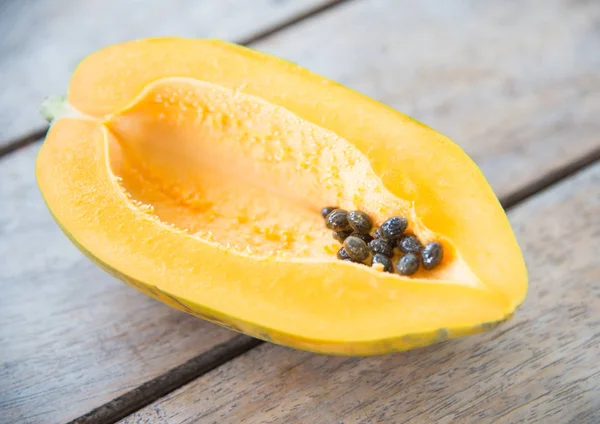 Ahşap masa üzerinde sarı papaya meyve.