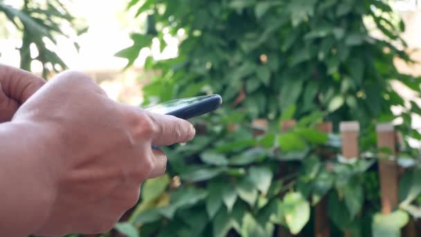 Primo Piano Mano Utilizzando Smartphone Stagno Giardino — Video Stock