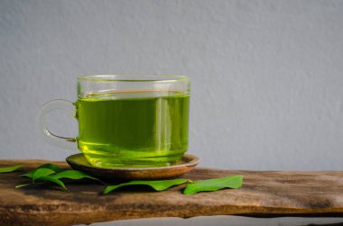 Gri arkaplanda yeşil çay iç.