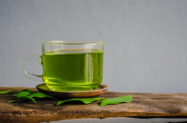 Pij zieloną herbatę na szarym tle. — Zdjęcie stockowe