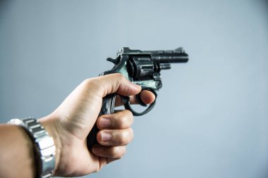 Gri arka plan üzerinde elinde silah.
