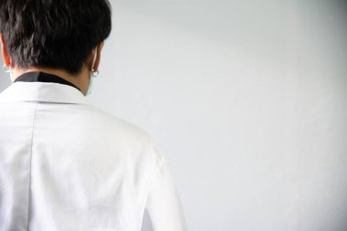 Gri arka planda beyaz önlüklü doktor..