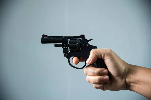 Pistol i handen på grå bakgrund. — Stockfoto