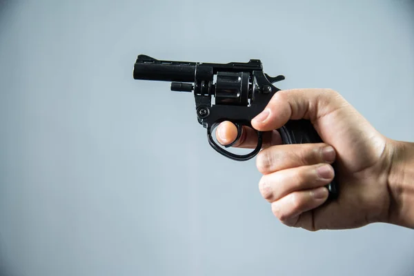 Pistol i handen på grå bakgrund. — Stockfoto