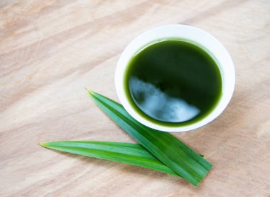 Tahta dokusunda pandan geen yaprağı olan bir kasedeki Tiliacora triandra suyu. Tayland yemeği ve yemek pişirme konsepti..