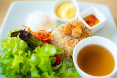 Beyaz tabakta yeşil marullu kızarmış pirinç somonu..