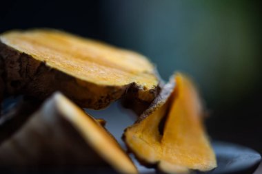 Ahşap masadaki sarı zerdeçal bitkisini kapat..