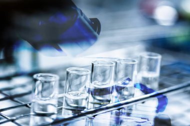 Coronavirus 'taki test tüpü ya da covid-19 analizci konsepti ile çift pozlama mikroskobu.