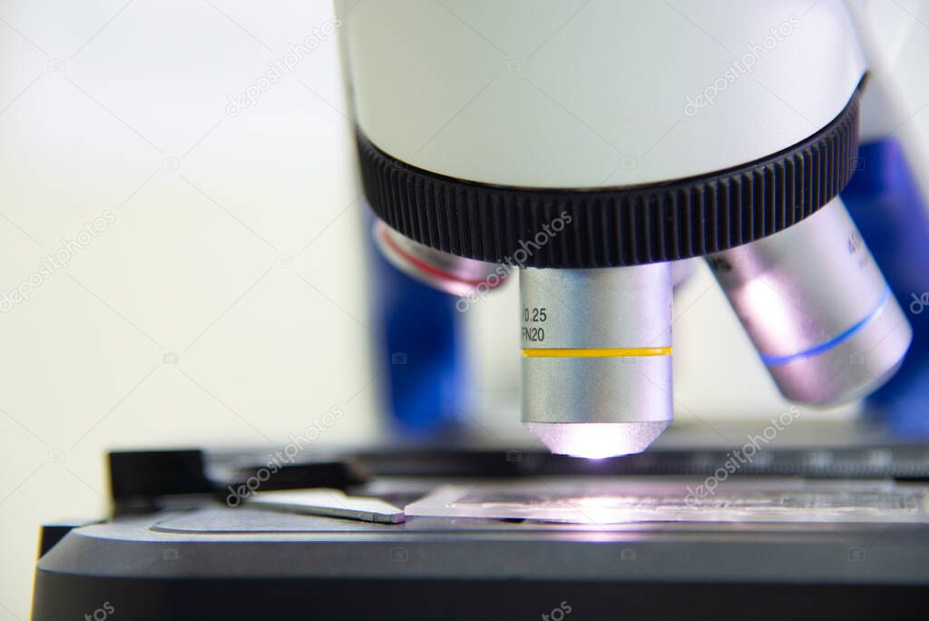 Close up objective lens microscope in laboratory.