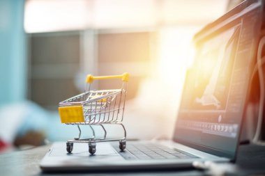 Sarı araba dizüstü bilgisayarda online alışveriş kavramında.