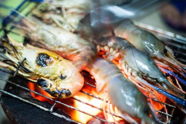 Kömür ocağında ızgara karides pişirme konsepti.