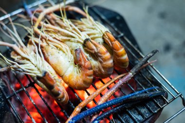 Kömür ocağında ızgara karides pişirme konsepti.