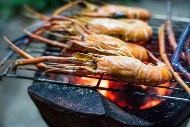 Kömür ocağında ızgara karides pişirme konsepti.