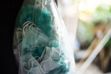 Corona ya da Covid-19 virüsünü önlemek için plastik poşette çöp cerrahi maskesi paketliyorum..