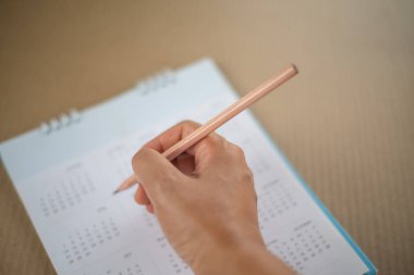 Planlama konseptinde takvimde kalem işaretlemesi ile eli kapat.