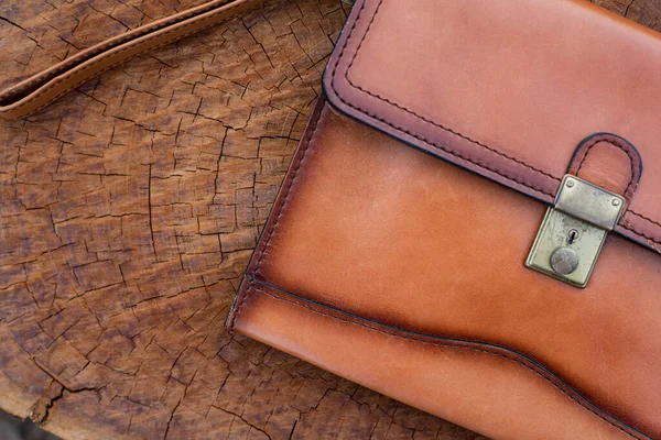 木製のテクスチャ上のブラウンレザー財布を閉じます ロイヤリティフリーのストック写真