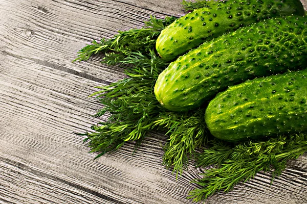 Frische grüne Gurken mit Dill auf Holztisch — Stockfoto