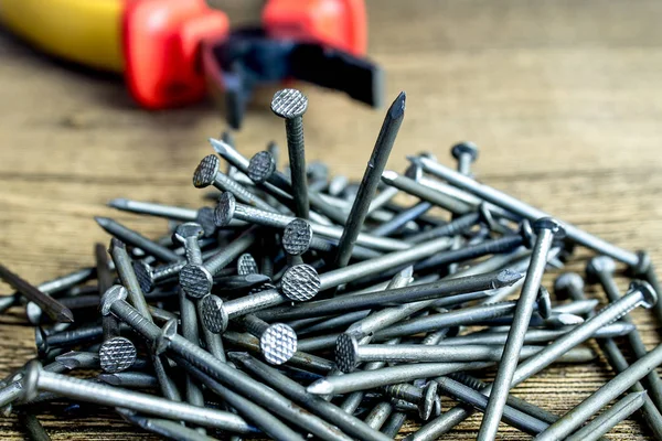 Clavos de metal en el fondo de las herramientas en la mesa de madera —  Fotos de Stock