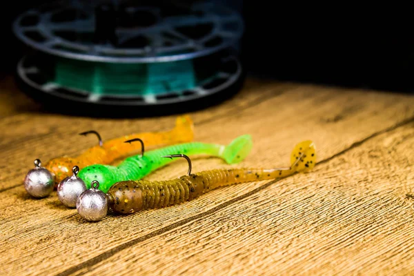 Jig fishing lures on a brown wooden table — Stock Photo, Image