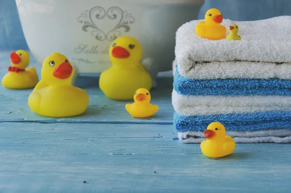 Pila de toallas de colores y pato de baño en la mesa — Foto de Stock