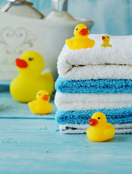 Stapel kleurrijke handdoeken en bad eend op tafel — Stockfoto