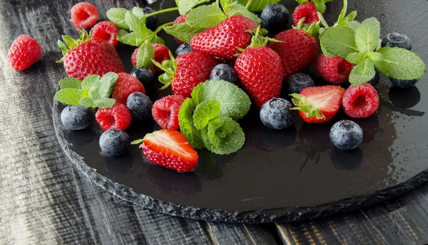 Fresh strawberries, raspberries and blueberries on a black background — Stock Photo, Image