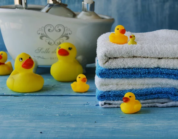 Stos kolorowe ręczniki i kąpieli kaczka na stole — Zdjęcie stockowe
