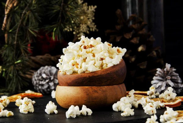 Popcorn in a wooden plate on the background of Christmas — Stock Photo, Image