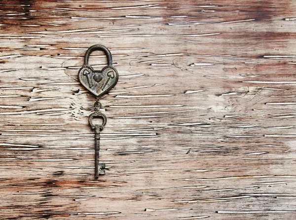 Ron key from the lock lying on wooden vintage background — Stock Photo, Image