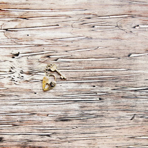Chiave ron e serratura sdraiato su uno sfondo vintage in legno — Foto Stock