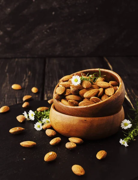 Raw almonds on wooden bowl, selective focus, space for text — Stock Photo, Image