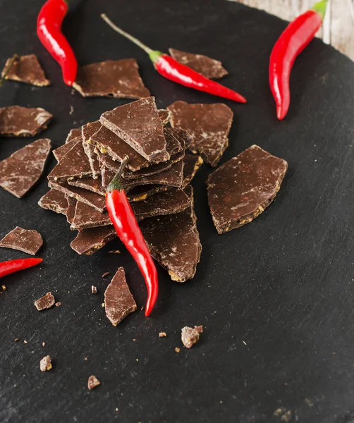 Kousky hořké čokolády s chilli na palubě černé uhlí — Stock fotografie