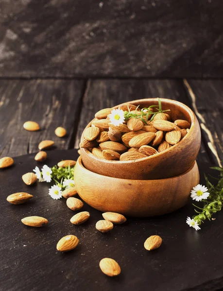 Raw almonds on wooden bowl, selective focus, space for text — Stock Photo, Image