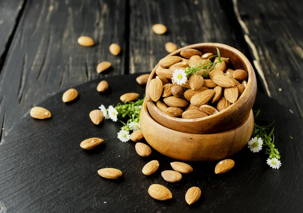 Raw almonds on wooden bowl, selective focus, space for text — Stock Photo, Image