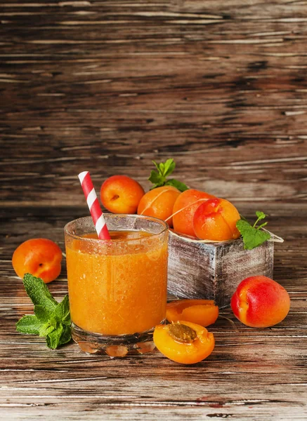 Taze kayısı suyu cam ahşap masa, seçici odak üzerinde